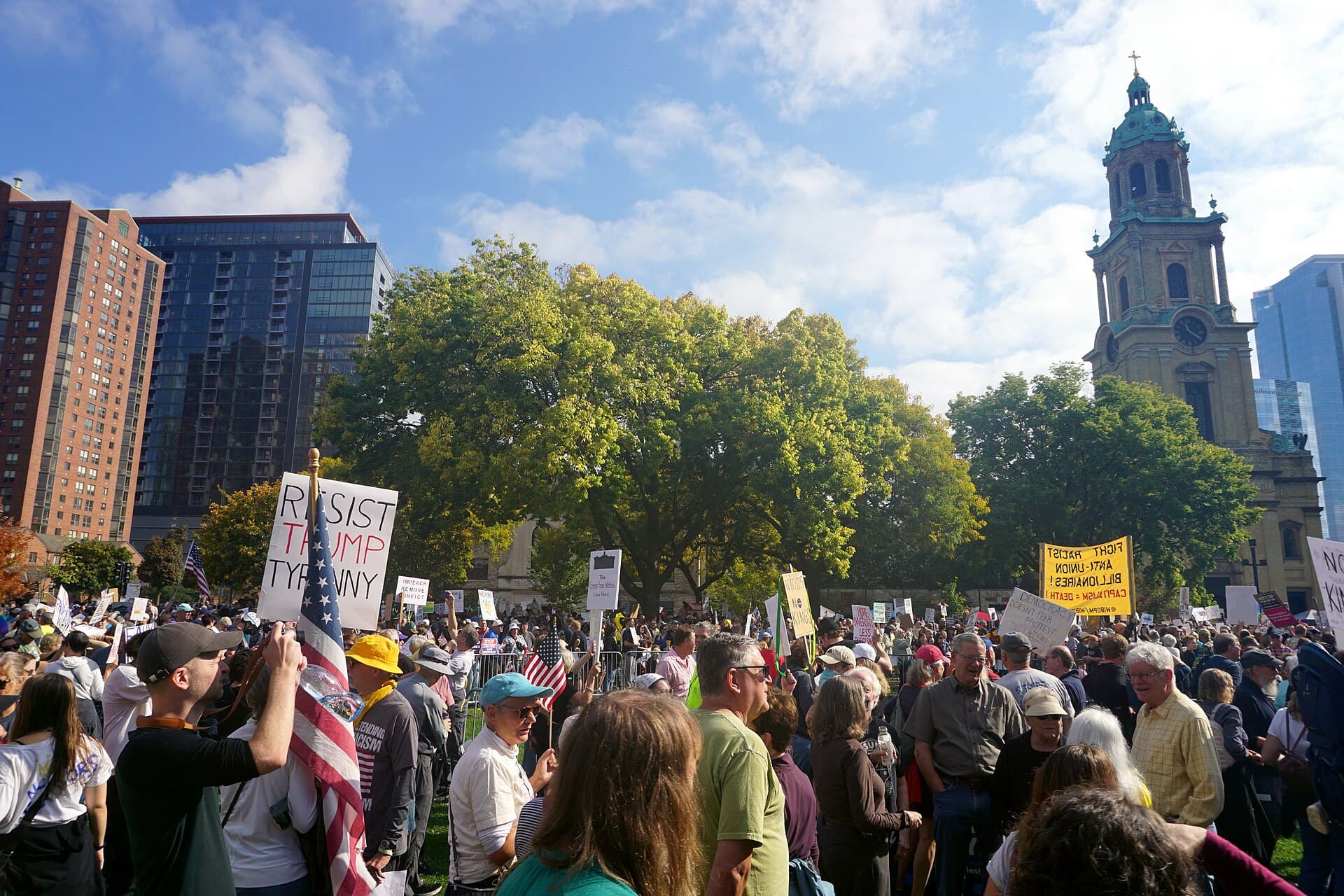 Protesters holding signs at a No Kings rally in Milwaukee in October 2025