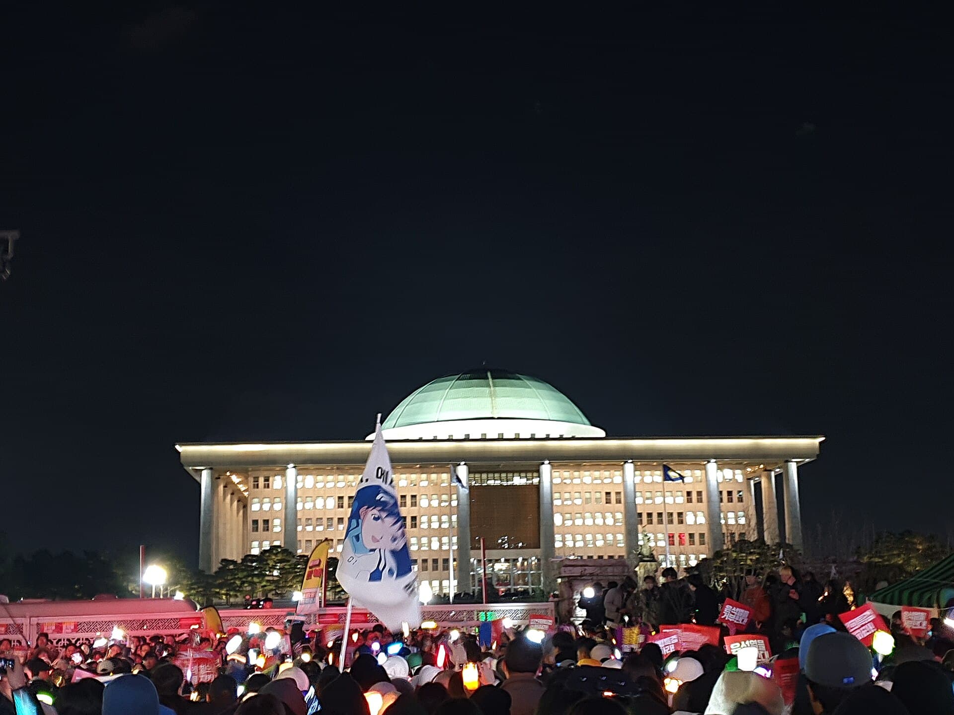 Crowds of protesters with light sticks rallying outside South Korea's National Assembly in December 2024
